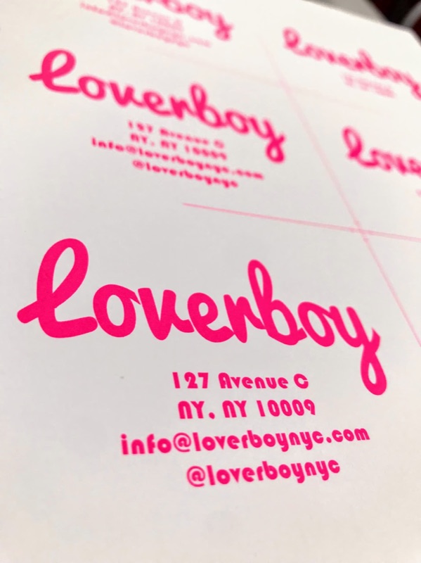 Fluorescent pink script business cards on the press sheet