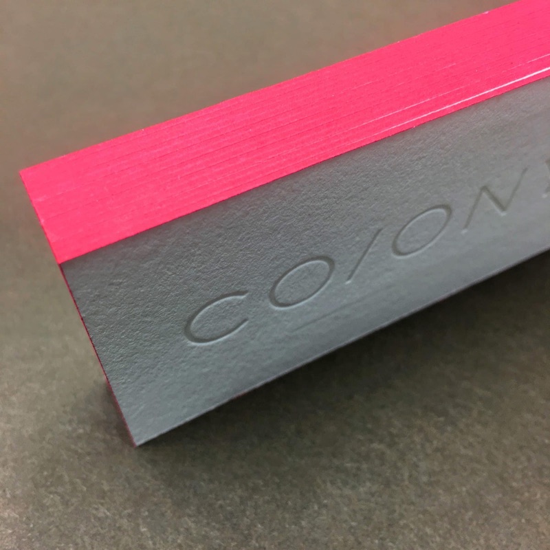 Hot pink fluorescent edge paint on a thick business card