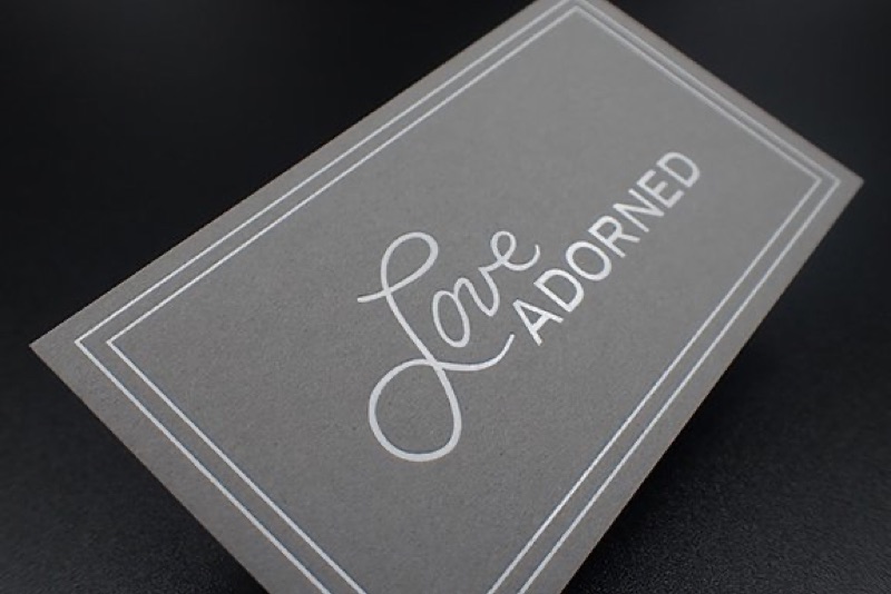 White foil script and border on gray business card