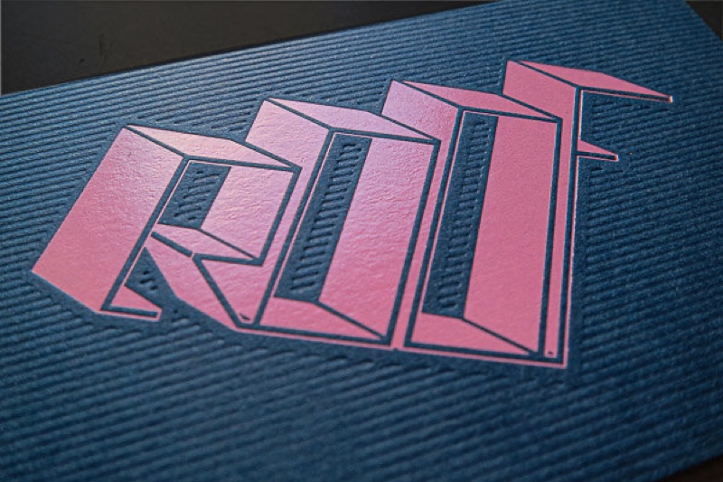 Pink letterpress lettering on navy textured card