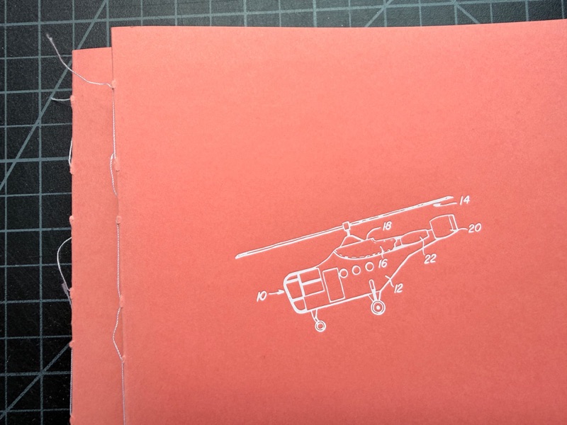 Singer sewn red booklet with helicopter line art